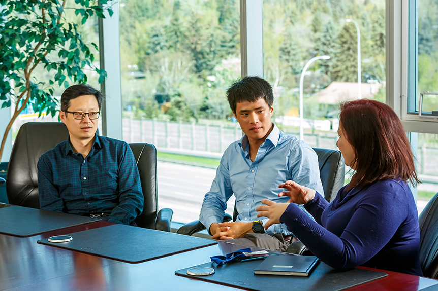 Diverse group of employees, gathered at a boardroom table